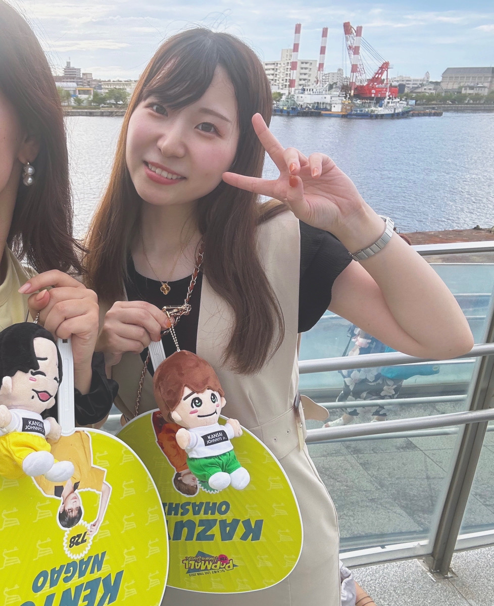 推しのうちわを持って笑顔のスタッフ