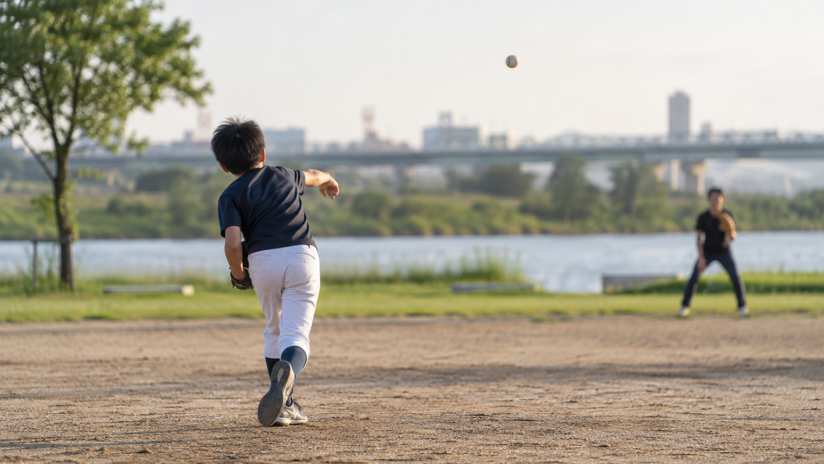 グラウンドでキャッチボールをする少年の様子(イメージ)