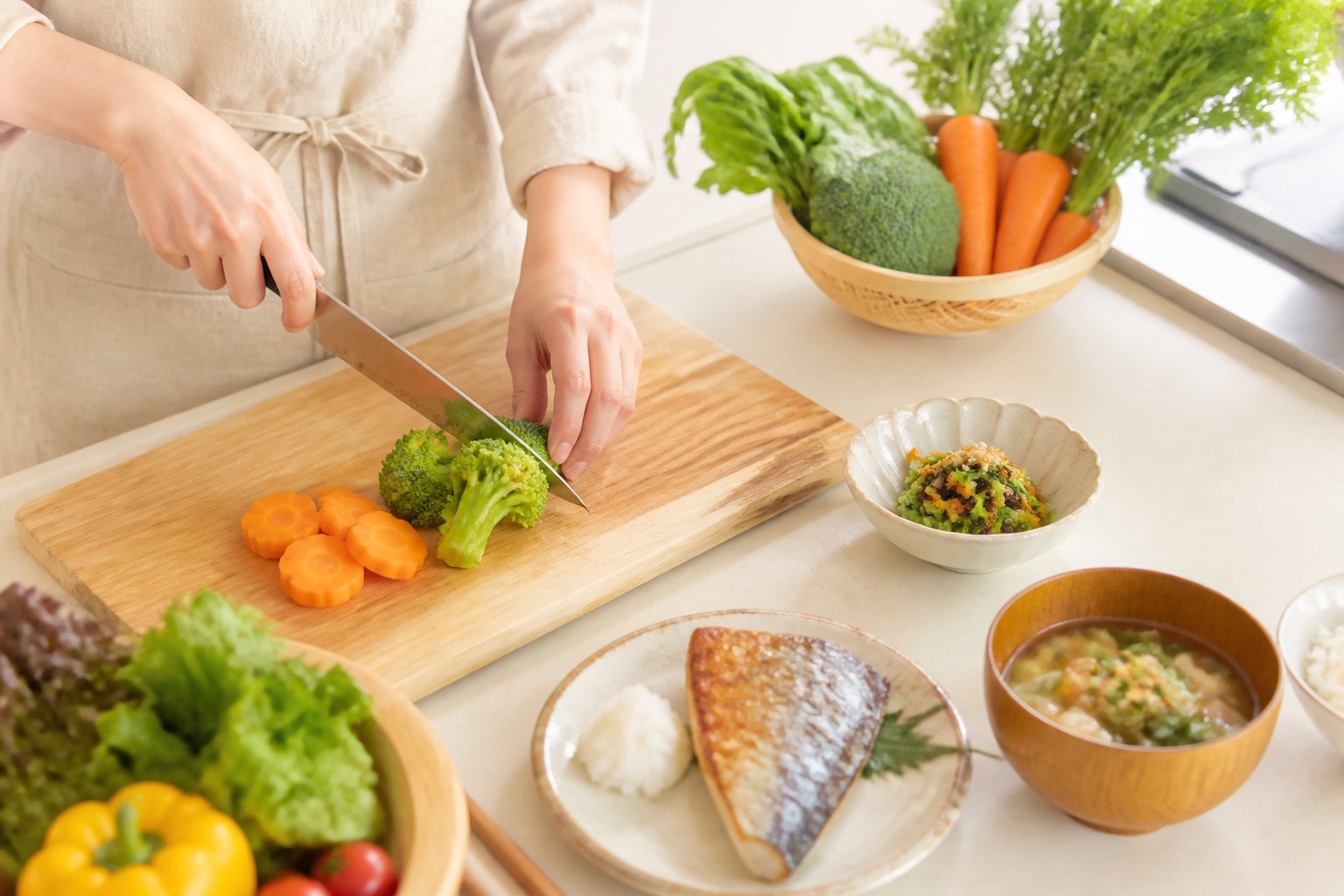 キッチンで野菜を切り、和食の器を並べている手元（イメージ）